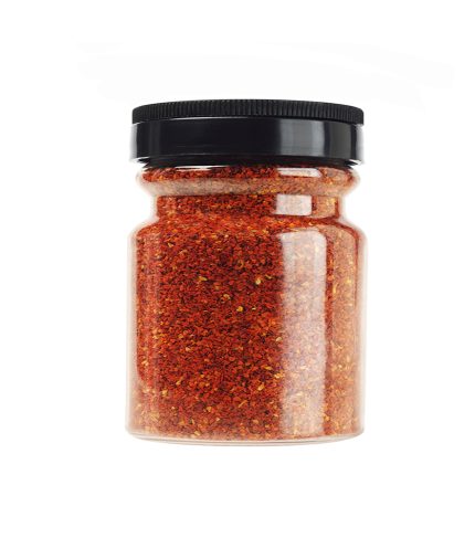 Bottle of Coarse Chilli Powder on White Background